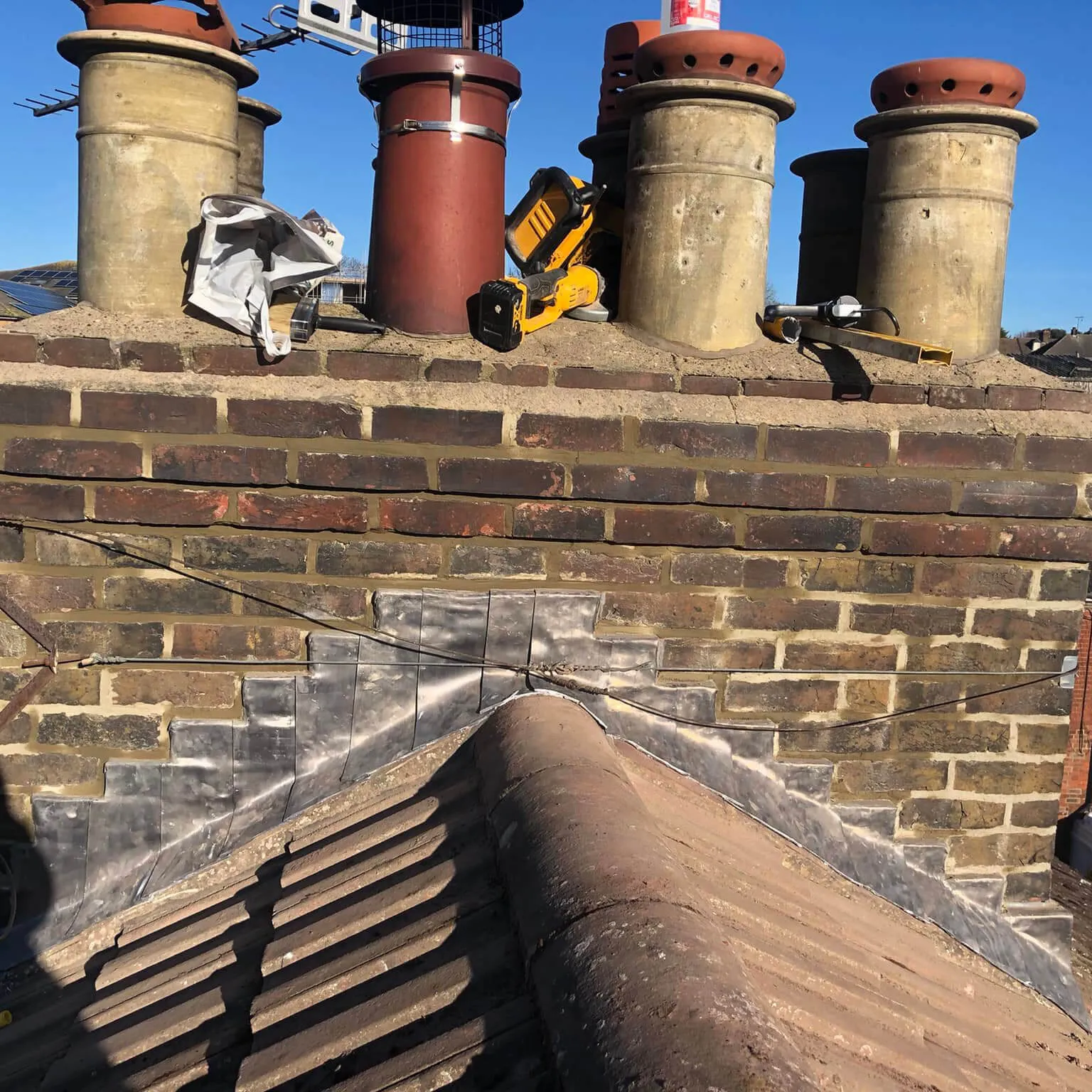 a brick wall with chimneys and a tiled roof