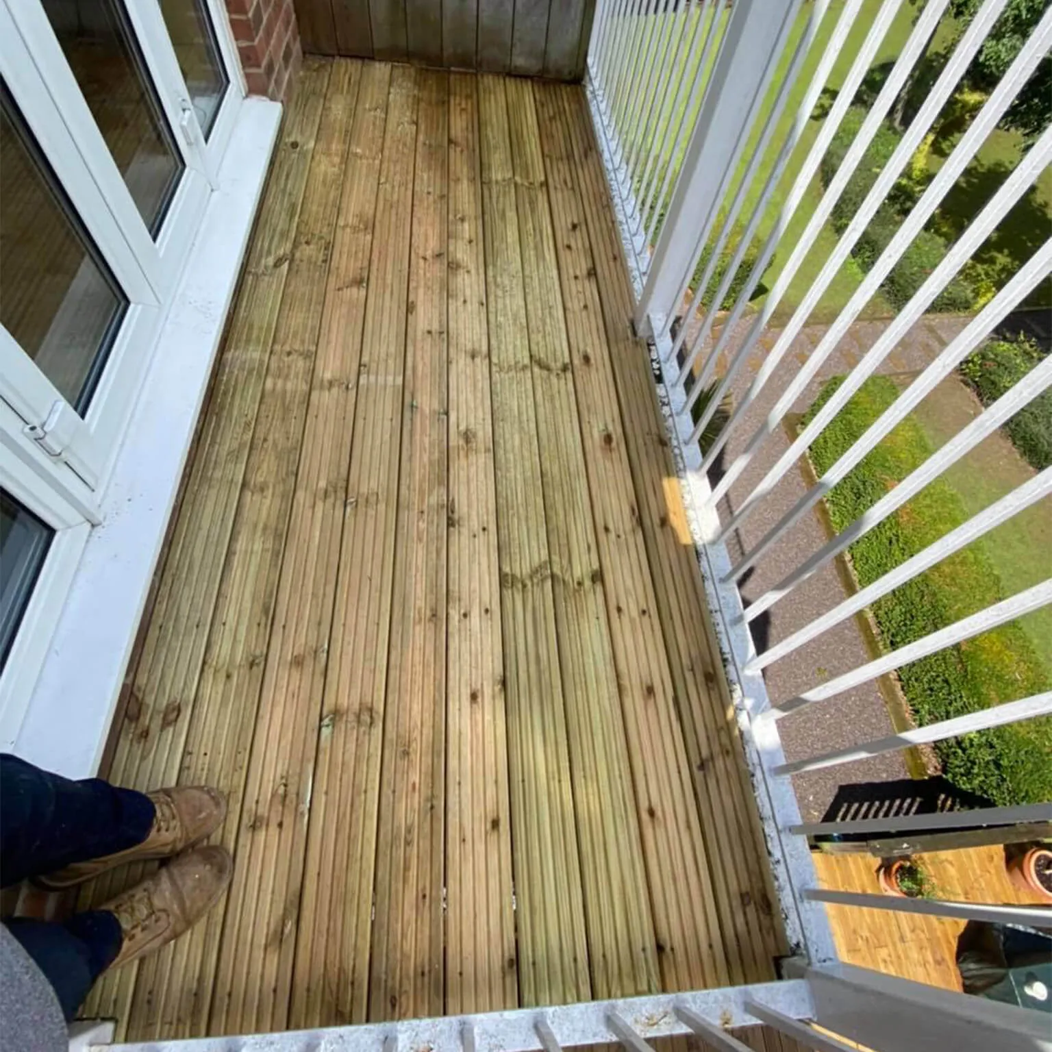 a person standing on a wooden deck next to a door